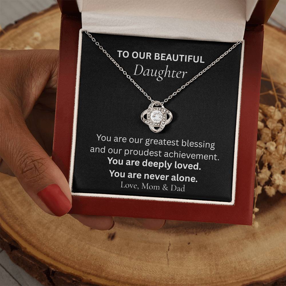 Love Knot necklace for daughter from mom and dad shown in gift box held by hands