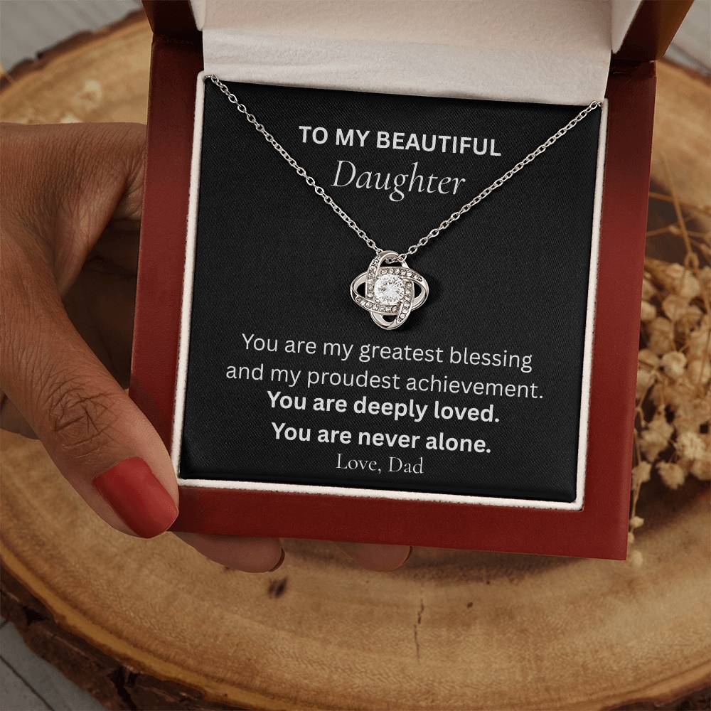 Love Knot necklace for daughter from Dad shown held in hands with message card