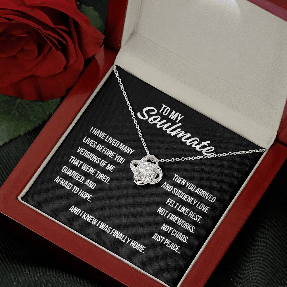 Angled view of to my soulmate love knot necklace in white gold with black background romantic message card