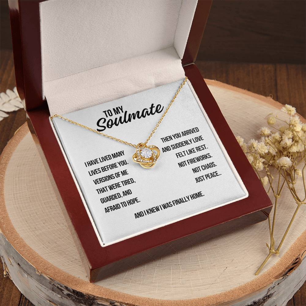 Yellow gold soulmate love knot necklace on white background with message saying love felt like rest not chaos just peace