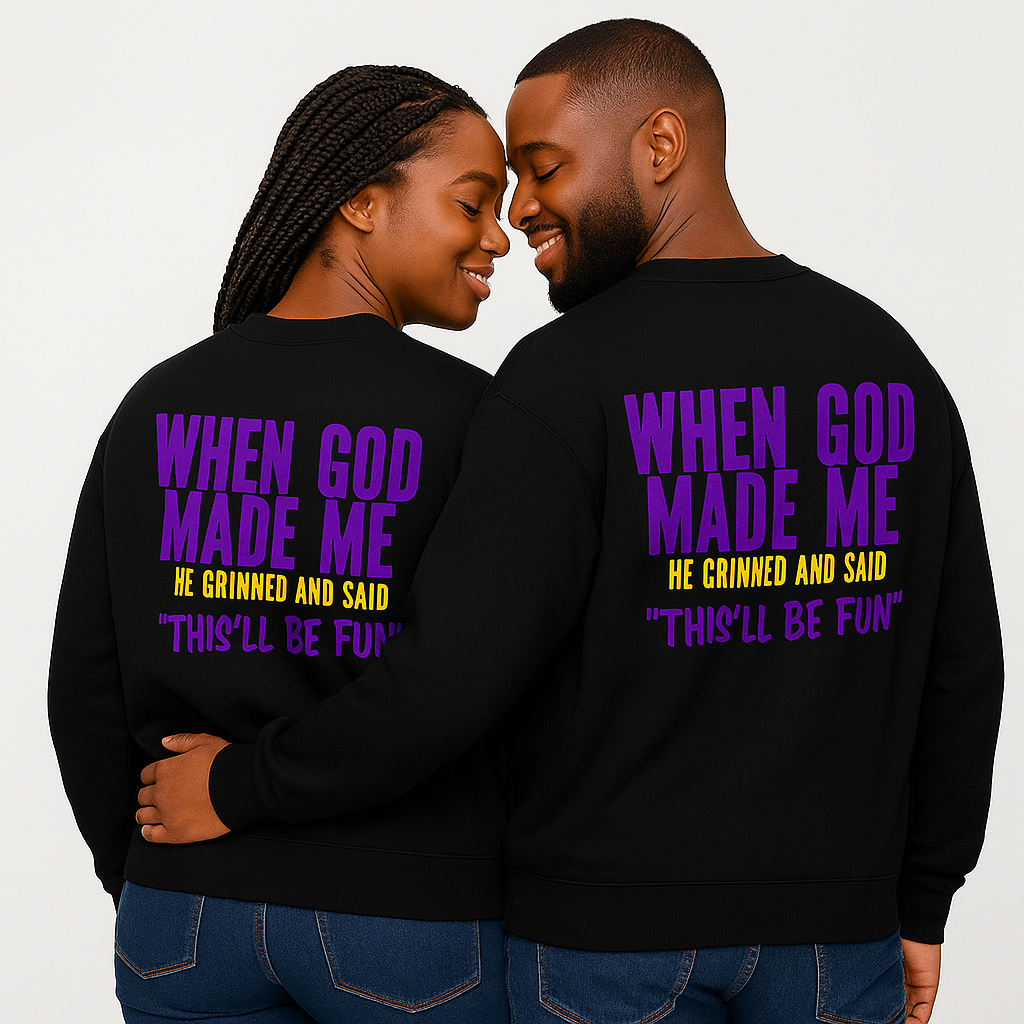 African American couple wearing matching black unisex crewneck sweatshirts with the faith and humor message When God Made Me He Grinned and Said This’ll Be Fun